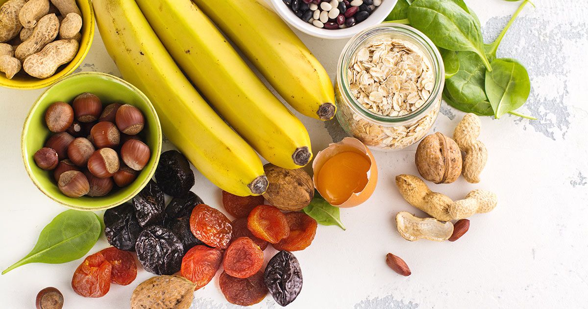 8 Signs You Are Deficient in Potassium Bananas, nuts, dried fruit, oats, beans and spinach on a table